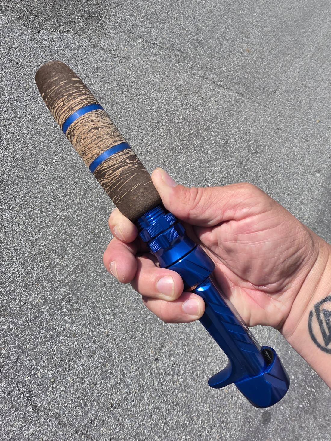 Blue custom rod handle held outdoors