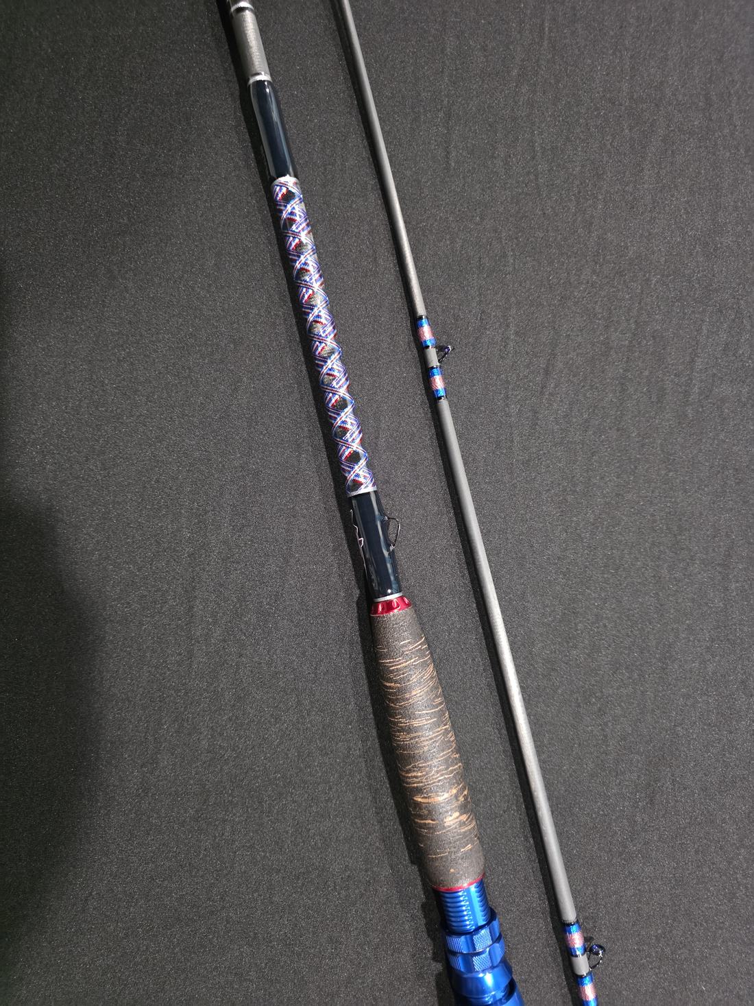Two black rods with blue wraps and natural grips against a dark backdrop